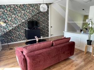 una sala de estar con un sofá rojo en una habitación en Central 1-bedroom Apartment with Bath & Balcony, en Tallin