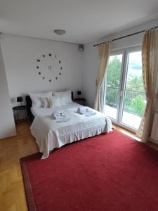 um quarto com uma cama branca e um tapete vermelho em Villa Kuna em Sarajevo