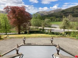 an external view of a garden with mountains in the background at Glenorchy Lodge Hotel-Rooms Only in Dalmally