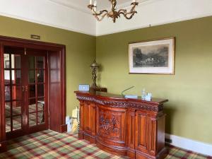 Glenorchy Lodge-Rooms Only في دالمالي: غرفة مع خزانة خشبية وصورة على الحائط