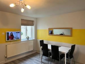 a dining room with a white table and black chairs at Swindon Home from Home 2 - EnterCloud9SA in Swindon