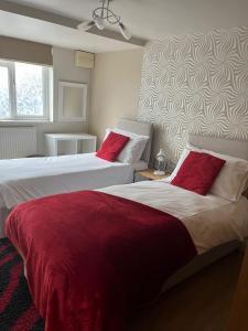 2 camas con almohadas rojas en un dormitorio en Swindon Home from Home 2 - EnterCloud9SA, en Swindon