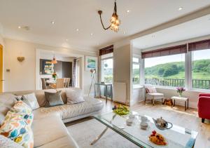 a living room with a couch and a glass table at Lindos in Looe