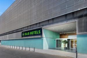 un grande edificio con un cartello sul lato di B&B HOTEL Logroño Las Cañas a Viana