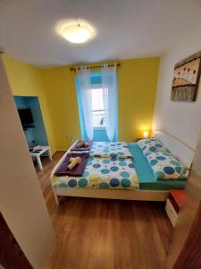 a bedroom with a bed in a room with a window at Apartmani Jadran in Mali Lošinj
