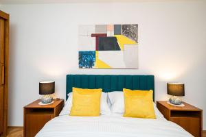 a bedroom with a bed with yellow pillows and a painting at Old Town Duodecim in Dubrovnik +17 photos