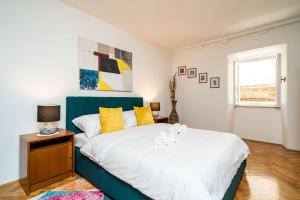 1 dormitorio con 1 cama grande con almohadas amarillas en Old Town Duodecim, en Dubrovnik