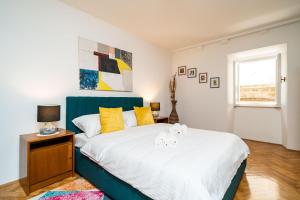 a bedroom with a large bed with yellow pillows at Old Town Duodecim in Dubrovnik