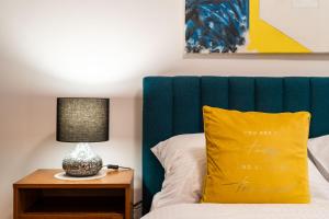 a bed with a green headboard and a yellow pillow at Old Town Duodecim in Dubrovnik