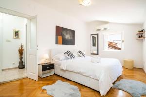 a white bedroom with a white bed and a window at Old Town Duodecim in Dubrovnik