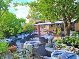 een terras met tafels en stoelen en een restaurant bij Domaine du Val de Sault in Sault-de-Vaucluse