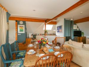 a living room with a wooden table and chairs at Sandy Combe in Bridport
