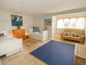 a living room with a couch and a chair at Sandy Combe in Bridport
