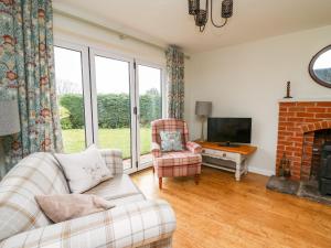 a living room with a couch and a fireplace at Applecroft in Coreley