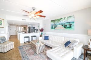ein Wohnzimmer mit einem weißen Sofa und einer Küche in der Unterkunft Windjammer 404 in St. Augustine