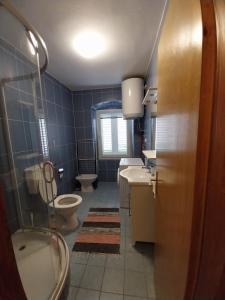 a bathroom with a toilet and a sink and a tub at Apartmani Jadran in Mali Lošinj