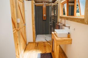 La salle de bains est pourvue d'une douche, d'un lavabo et d'un miroir. dans l'établissement AfriCamps at de Pakhuys, Cederberg, à Cederberg