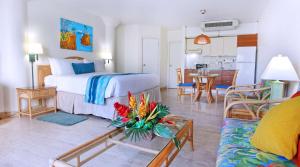 LowlandsにあるRoyal Islander Club Resort La Plageのベッドとリビングルームが備わるホテルルームです。