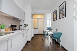 a kitchen with white cabinets and a table and chairs at Cozy Antwerp - Cityview Studio FREE PARKING in Antwerp