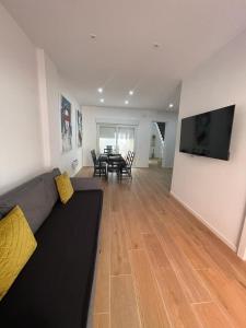 salon z kanapą i stołem z krzesłami w obiekcie UIM Mediterraneo CASA Sepulveda Wifi w mieście Puerto de Sagunto