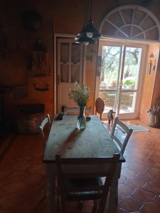 a dining room table with a vase of flowers on it at Morelli House in Montalbo