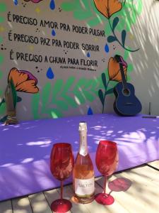 a bottle of wine and two wine glasses on a table at Casa Viva Bonito in Bonito