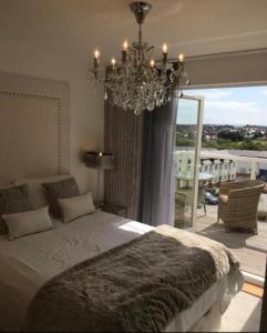 um quarto com uma cama grande e um lustre em Cardiff luxury apartments em Cardiff