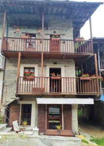 a building with a balcony with flowers on it at Da Meme' in Paesana