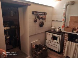 a kitchen with a stove with pots and pans on the wall at Da Meme' in Paesana