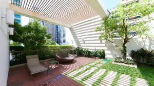 une terrasse extérieure avec une chaise et un arbre dans l'établissement Citiresort Living sukhumvit 39, à Makkasan
