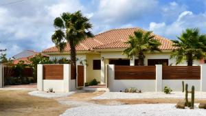 una casa con una valla y palmeras en Endless Summer, en Palm-Eagle Beach