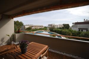a balcony with a wooden bench and a swimming pool at Pausa Mare Seaside in Torre a Mare