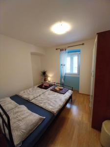 a bedroom with two beds and a window at Apartmani Jadran in Mali Lošinj