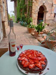 una botella de vino junto a un plato de fresas en Morelli House, en Montalbo