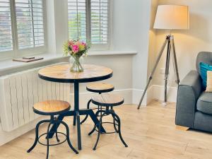 a table with two stools and a vase of flowers at Moorgate View - Free on street Parking in York