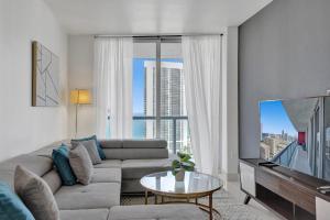 a living room with a couch and a large window at Stunning Beach Resort Large 4BR 3BA Condo 24 FL in Hallandale Beach