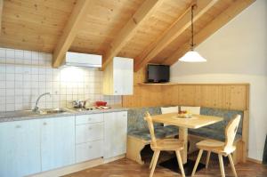 a kitchen with a table and chairs in a room at Ciasa Mira - BelaVal Apartments in La Villa