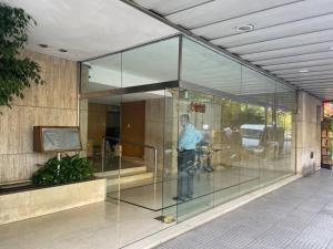 a man standing inside of a glass building at Spacious 5BR Classic Apt in Palermo in Buenos Aires