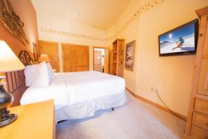 a bedroom with two beds and a flat screen tv at Arapahoe Lodge 8105 in Keystone