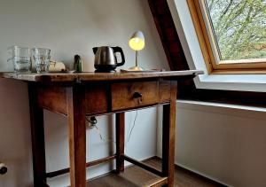 a table with a lamp on it next to a window at de Zeeuwse Hemel in Zierikzee