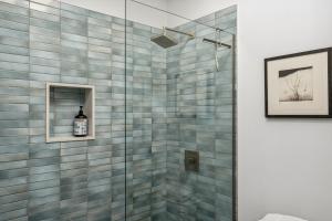 a bathroom with a shower with blue tiles at 4 Square Studios in Phoenix