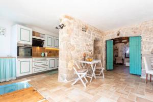 a kitchen with a table and a stone wall at Holiday house with a swimming pool - Villa Melavita in Stari Grad