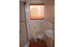 a bathroom with a toilet and a sink and a window at 1 Bedroom Cozy Home In Neeberg in Neeberg