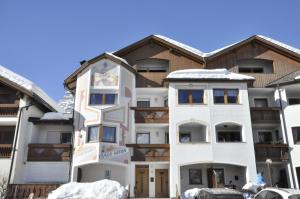 an apartment building with snow on the ground at Ciasa Mira - BelaVal Apartments in La Villa