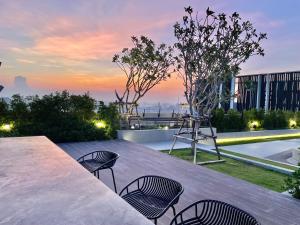 a patio with chairs and a table on top of a building at Srinakarin Lasalle 2 BR Bangkok in Bangna