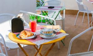 a table with a breakfast of croissants and a drink at Ci Thorno Hotel in Crosia