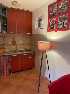Comfortable Villa Oliva في كانج: مطبخ مع دواليب حمراء ومصباح في الغرفة
