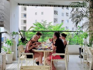 a group of people sitting at a table eating food at Chez Lotus Rose in Ho Chi Minh City