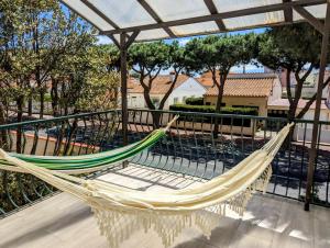 a hammock on the balcony of a house at KiWi in Canet-en-Roussillon