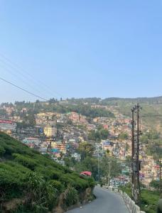 a winding road on a hill with a city at Greenery Homestay in Darjeeling